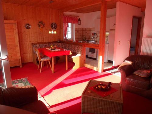 ein Wohnzimmer mit einem Tisch und einer Küche in der Unterkunft Familienfreundliche Ferienwohnung direkt in der Natur in Eichenbach