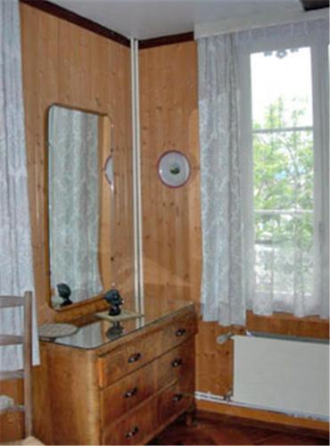 a wooden dresser with a mirror and a window at Apartments Dr. Med. Vet. Tempelman in Interlaken