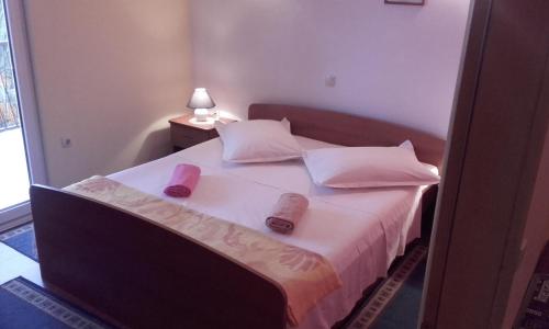a bedroom with a bed with two slippers on it at Apartments Ivka in Omiš
