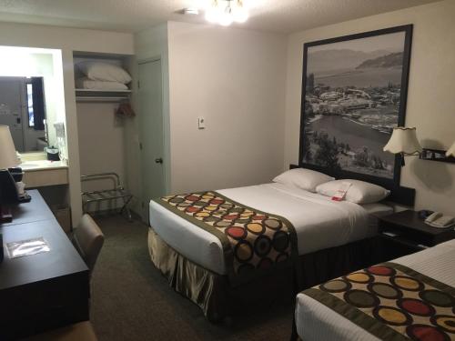 a hotel room with two beds and a desk at Super 8 by Wyndham Kelowna BC in Kelowna