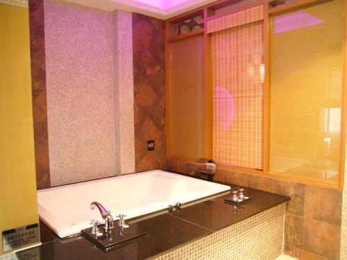 uma casa de banho com uma banheira e uma janela em Sexy City Motel em Tainan