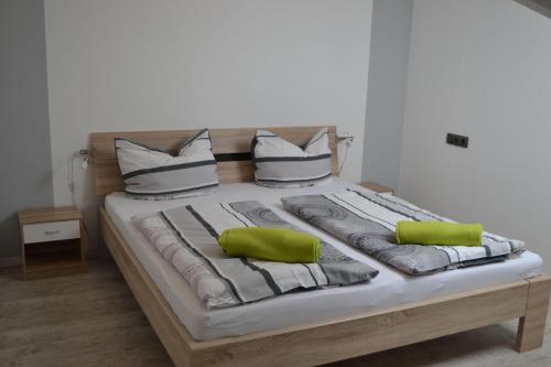 1 cama grande con 2 almohadas verdes en App-Duenenblick-Haus-Loreley en Sankt Peter-Ording