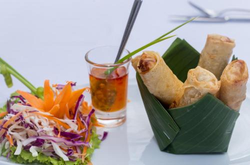 a bowl of food next to a salad and a drink at Damrei Residence & Spa in Siem Reap