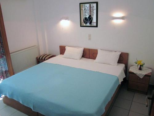 a bedroom with a large bed with a blue blanket at Mochlos Mare in Mochlos