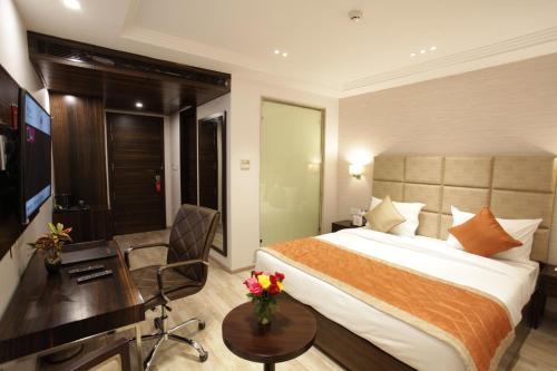 a hotel room with a bed and a desk at Kaisons Inn (Near Apollo Hospital) in New Delhi