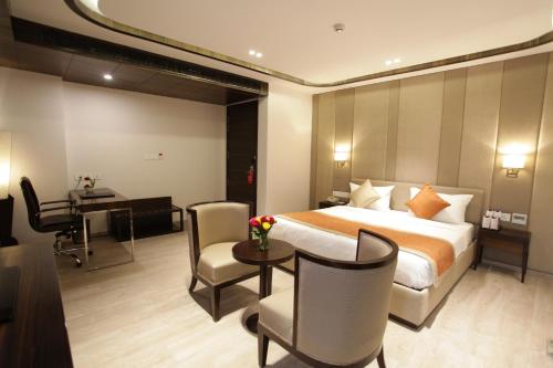 a hotel room with a bed and a desk at Kaisons Inn (Near Apollo Hospital) in New Delhi