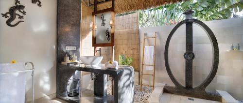 a bathroom with a bath tub in a room at Palm Garden Amed Beach & Spa Resort Bali in Amed