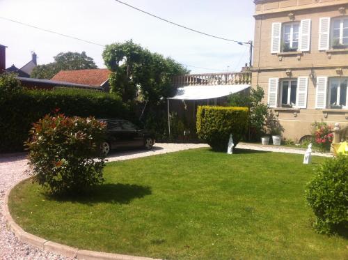 a yard with a car parked in front of a house at O Mylle Douceurs in Le Crotoy