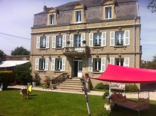 a house with a red tent in front of it at O Mylle Douceurs in Le Crotoy