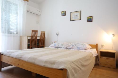 a bedroom with a bed and a table and chairs at Apartment and rooms Roko in Zaglav