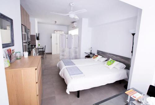 Un dormitorio blanco con una cama y un escritorio. en Apartamento Malagueta Beach 10, en Málaga