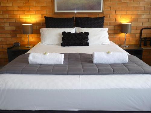 a large white bed with two pillows on it at Sunseeker Motel in Hervey Bay