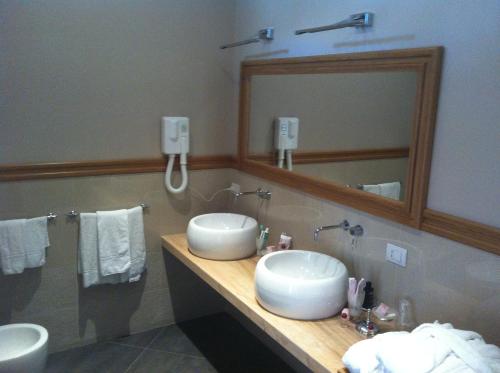 a bathroom with two sinks and a mirror at Hotel Il Barocco in Ragusa