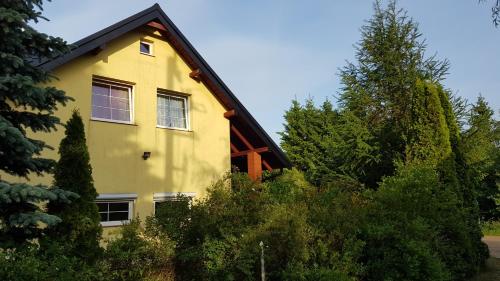 a yellow house with a gambrel roof at Dom u Kapitana w Lubiatowie in Lubiatowo