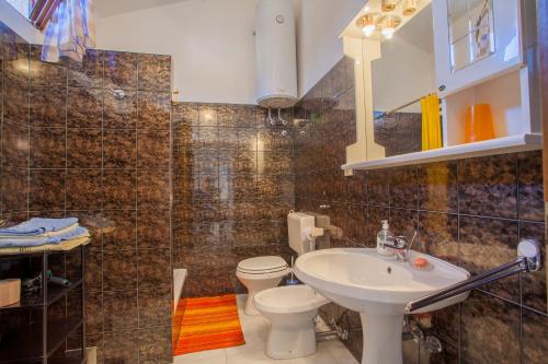 a bathroom with a sink and a toilet at Rooms Ester in Cres