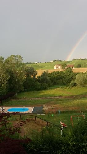 a rainbow in the distance with a playground and a pool at I Boidi in Nizza Monferrato
