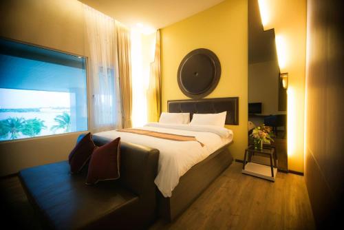 a bedroom with a large bed and a window at The Beverly Hills Hotel in Nakhon Ratchasima
