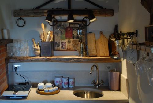 a kitchen counter with a sink and a shelf with utensils at Borgo San Gusmè in San Gusmè