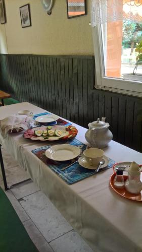 stół z talerzami i naczyniami na górze w obiekcie Cseppkő Panzió w mieście Abaliget
