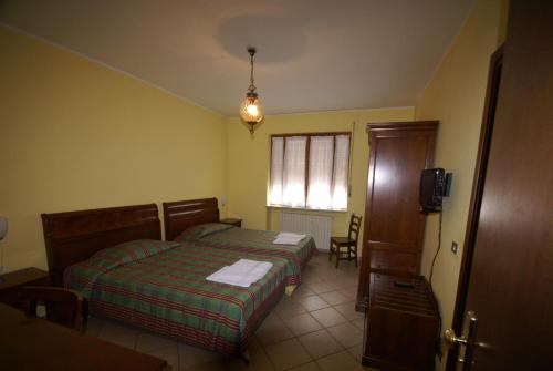a small bedroom with a bed and a window at Hotel Londra in Acceglio
