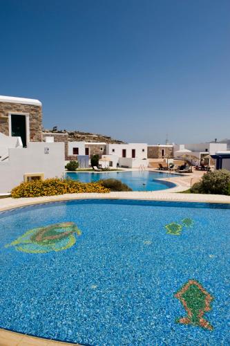 a large blue swimming pool in front of a house at Naxos Palace Hotel in Stelida