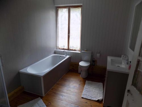 e bagno con vasca, servizi igienici e lavandino. di Country House - Spacious and Tranquil a Brétigny