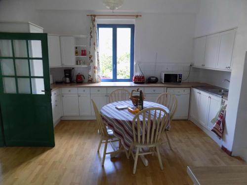 une cuisine avec une table et des chaises et une fenêtre dans l'établissement Country House - Spacious and Tranquil, à Brétigny