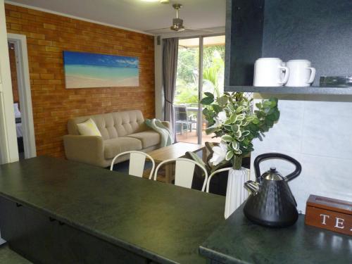 a kitchen with a counter top and a living room at Sunseeker Motel in Hervey Bay