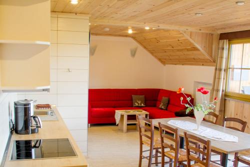 a living room with a red couch and a table at Birkholmhof in Bärnau