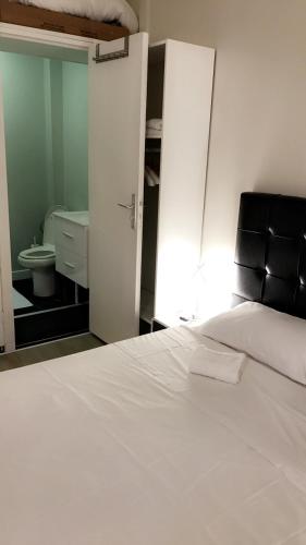 パリにあるSuite Cocoon Parisのベッドルーム(白いベッド1台付)、バスルーム(トイレ付)