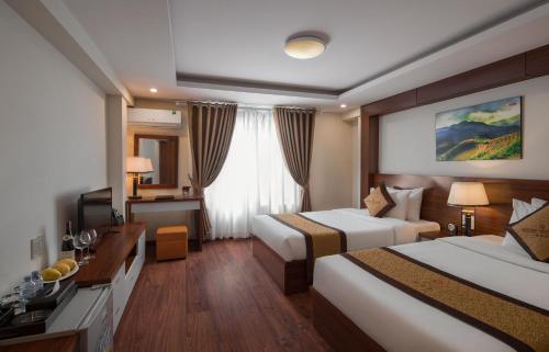 um quarto de hotel com duas camas e uma televisão em Golden Villa Sapa Hotel em Sa Pa