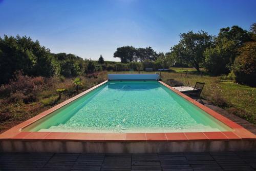- une piscine d'eau dans une cour avec une chaise dans l'établissement Berdale, à Lagraulet-du-Gers
