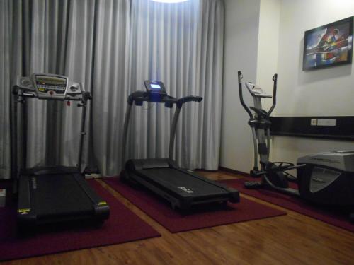 a gym with two exercise bikes and a treadmill at E Hotel in Chennai