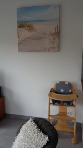 a living room with a chair and a painting on the wall at An en Bie in Aagtekerke