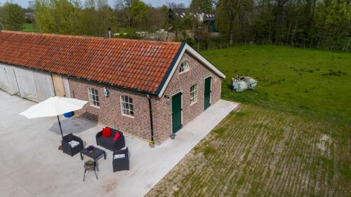 an overhead view of a building with an umbrella and chairs at B&B It Waldspultsje in Kollumerzwaag