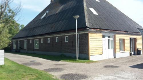 a large brick building with a black roof at Apartment Vredehof in Sint Maartensbrug