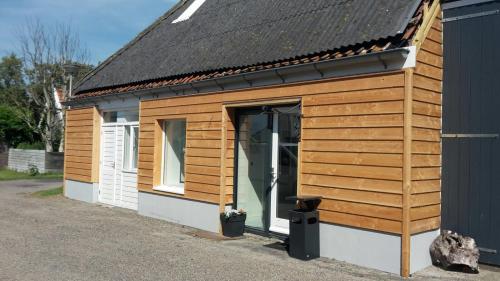 a wooden shed with a door on the side at Apartment Vredehof in Sint Maartensbrug