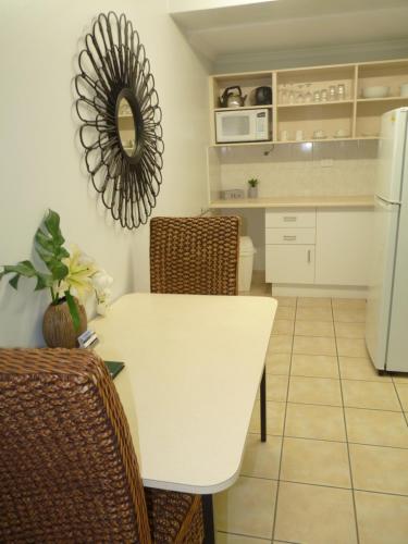 a kitchen with a white table and a white refrigerator at Sunseeker Motel in Hervey Bay