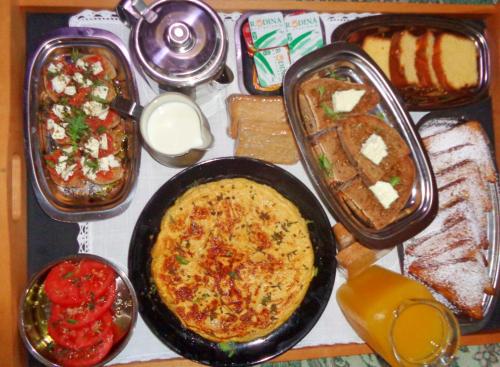 a table with a pan of food and different types of bread at Menina Farm Kalamata Countryside in Perivolákia
