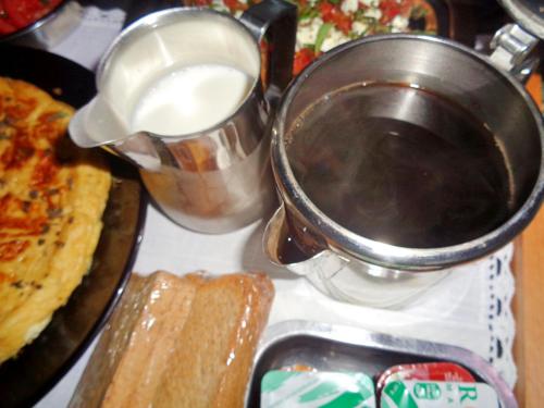 a stove top with a pot of milk and some food at Menina Farm Kalamata Countryside in Perivolákia