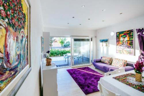 a living room with a purple couch and a purple rug at Boutique Villa Nirvana in Pag