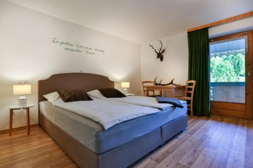 een slaapkamer met een groot bed en een groot raam bij Alpenferienwohnungen Wiesenlehen in Berchtesgaden