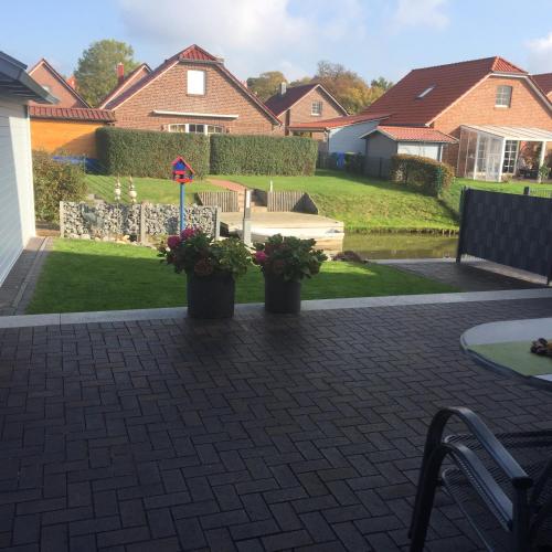 a patio with two potted plants in a yard at Skippersin2 in Greetsiel