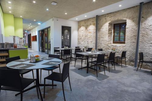 ein Restaurant mit Tischen und Stühlen in einem Zimmer in der Unterkunft Taste Style Hotel Bären Auggen in Auggen