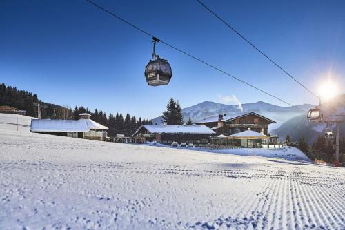 a snow covered ski slope with a ski lift at AlpenOase Sonnhof in Saalbach Hinterglemm