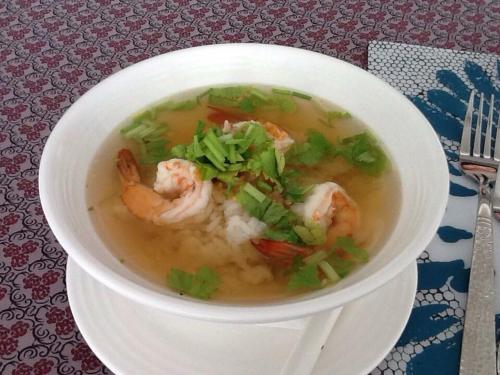 a bowl of soup with shrimp and vegetables on a table at BC Summer Beach in Pran Buri