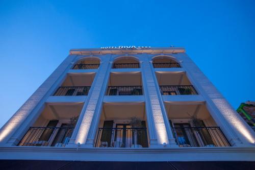 a tall building with a blue sky in the background at Hotel Riva by Aycon in Petrovac na Moru