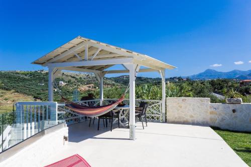 a gazebo with a hammock on a patio at Sea View Villas in Episkopí- Rethimno