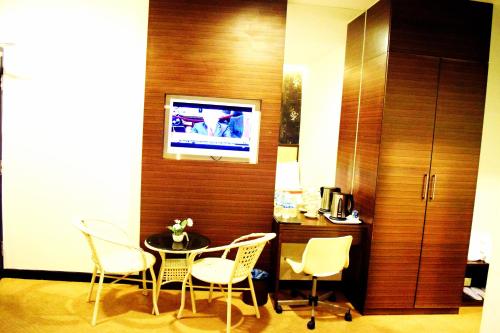 Habitación con mesa, sillas y TV. en Springz Hotel-Bukit Jalil en Kuala Lumpur