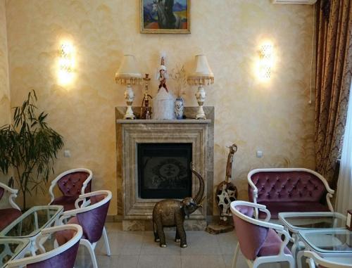 a living room with a fireplace and chairs and a table at Эдельвейс in Almaty